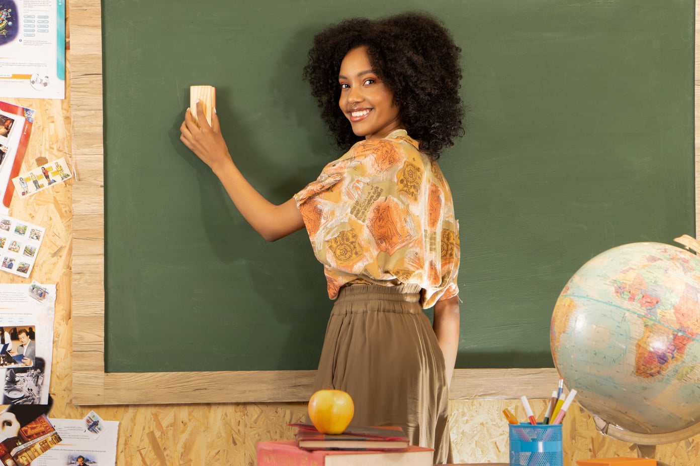 Smiling Female Teacher Cleaning the Chalkboard